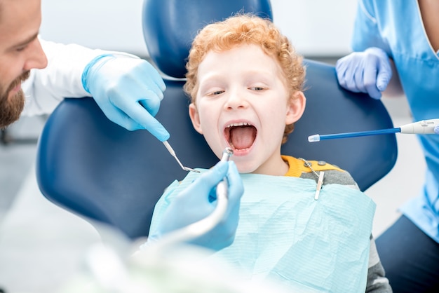 Foto menino durante o procedimento odontológico no consultório odontológico