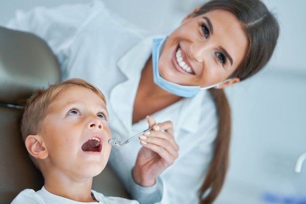 Menino e dentista no consultório do dentista