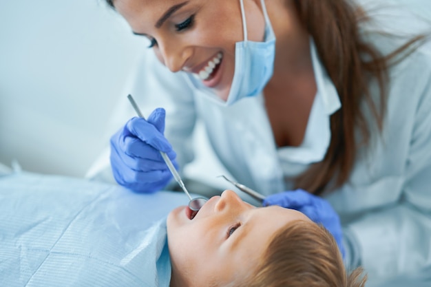 Menino e dentista no consultório do dentista