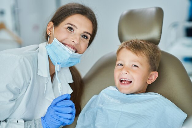 Menino e dentista no consultório do dentista