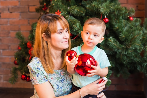 menino e mãe com bolas de natal
