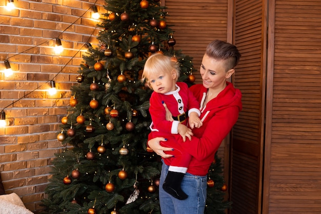 Menino e mãe em uma sala com decoração festiva para o Natal