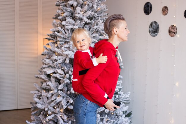 Menino e mãe felizes em uma sala de decoração festiva para o Natal