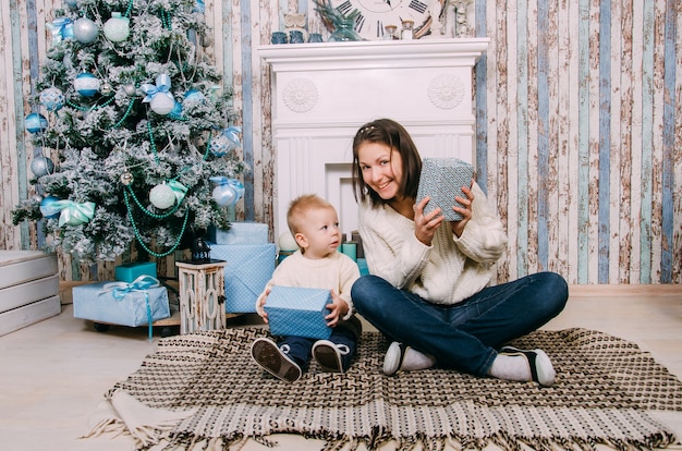 Menino e mãe perto de árvore de natal