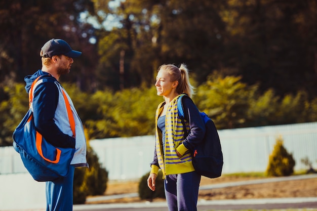 Foto menino e menina antes do treino conversando no estádio, preparando-se para o treino