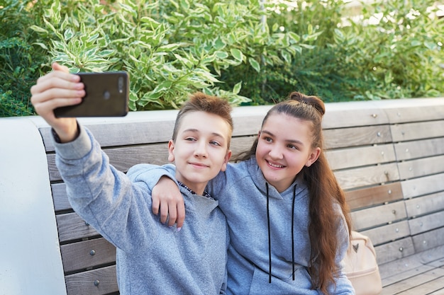 Menino e menina crianças adolescentes tomam selfie no celular. Conceito de amizade. Melhores amigos.