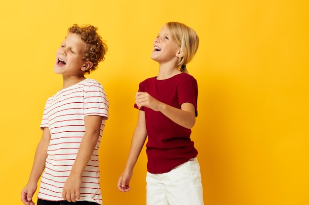 Menino e menina de pé lado a lado posando fundo isolado de emoções de infância