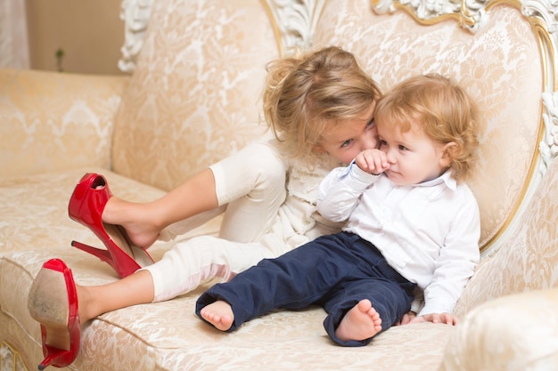 Menino e menina em sapatos vermelhos de mães