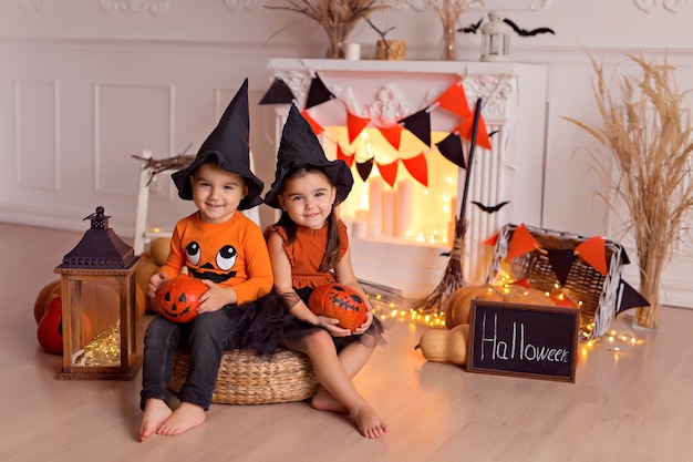 Menino e menina engraçados em fantasias de bruxa de halloween