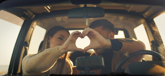 Foto menino e menina felizes no carro fora de estrada durante o dia dos namorados