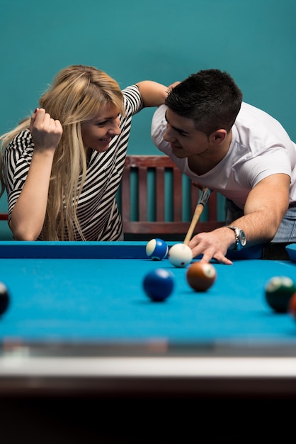 Menino e menina flertando em um jogo de sinuca