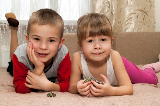 Menino e menina irmão e irmã brincando junto com pequenas tartarugas animais animais de estimação