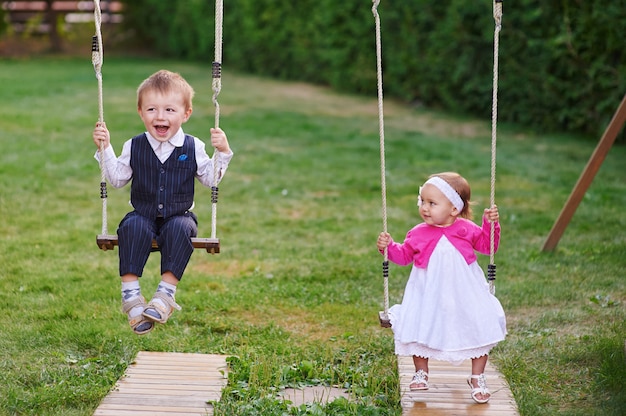 Menino e menina passeio no parque em um balanço