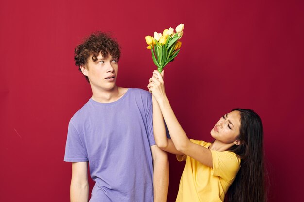 Menino e menina presentes buquê de flores divertido fundo vermelho inalterado