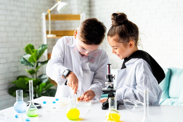 Menino e menina realizam um experimento científico educação experimentos químicos