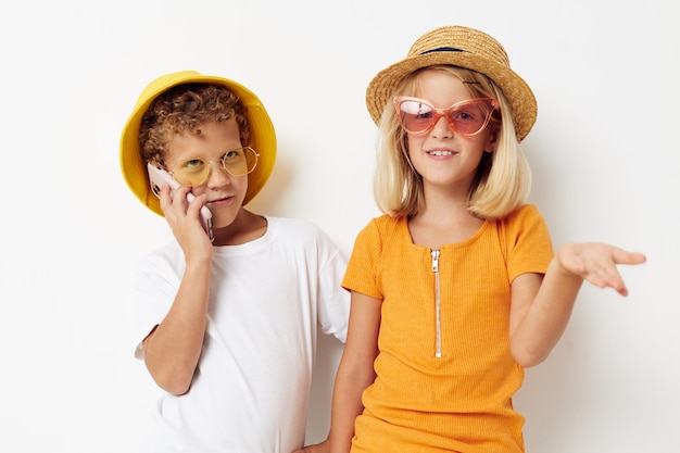 Menino e menina usando chapéus com moda de telefone posando infância