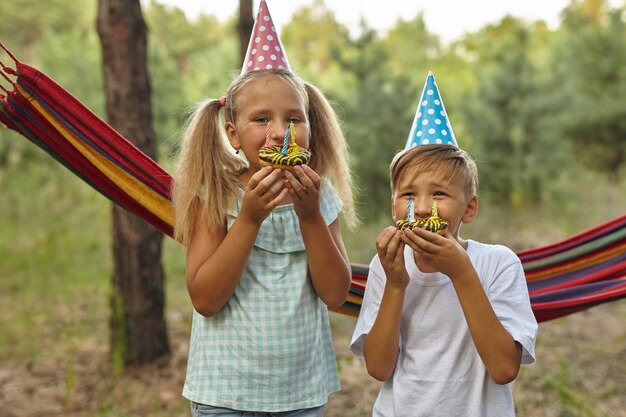 Menino e meninas comemorando aniversário ao ar livre no jardim