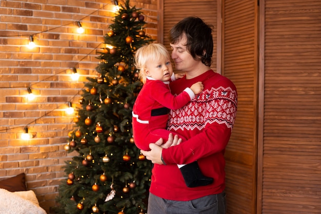 Menino e pai felizes em uma sala de decoração festiva para o Natal