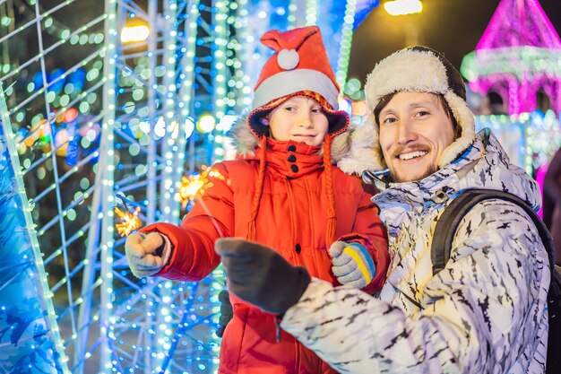 Menino e seu pai com estrelinhas de iluminação de Natal no Natal