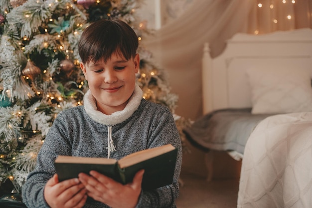 menino em decorações de natal lendo livro