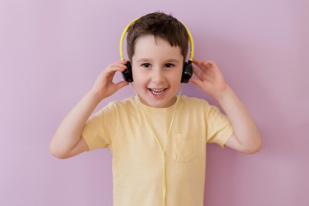 Menino em fones de ouvido no fundo rosa