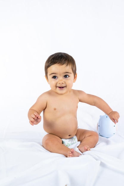 Menino em um estúdio com um fundo branco, oito meses, caucasiano, recém-nascido, sentado, sorrindo, foto vertical