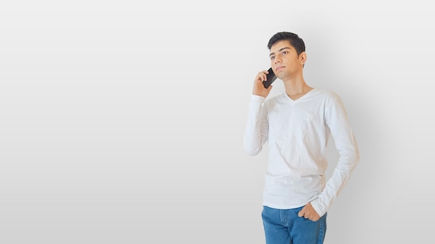 Menino em uma camiseta branca e segurando um telefone celular