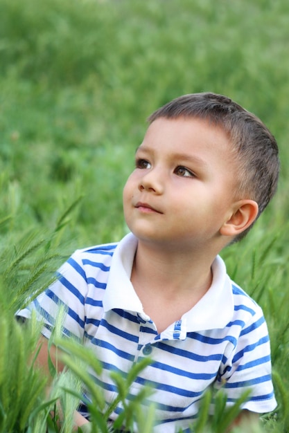 Menino em uma clareira verde