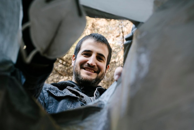 Menino em uma coleta de lixo depositando uma máscara em um saco de lixo fotografado por dentro