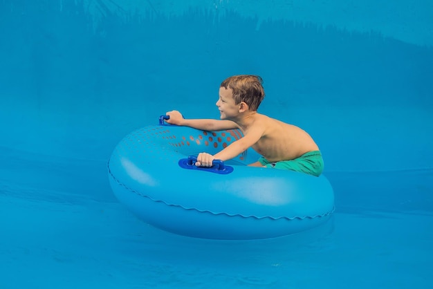 Menino em uma piscina flutua em ondas artificiais em um parque aquático