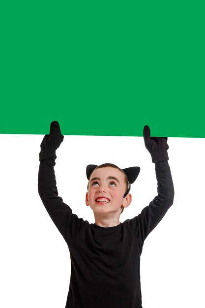 Menino emocional vestido como um gato preto com cartaz verde Isolado Purim Halloween