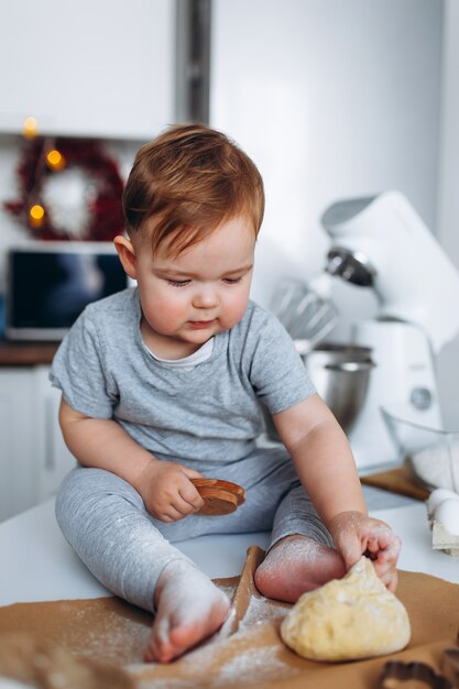 Menino engraçado família feliz preparando a massa, assar biscoitos na cozinha