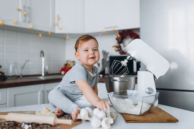 Menino engraçado família feliz preparando a massa, assar biscoitos na cozinha