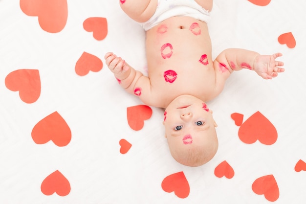 Menino entre corações e com beijos de batom vermelho, o conceito de amor e o dia dos namorados