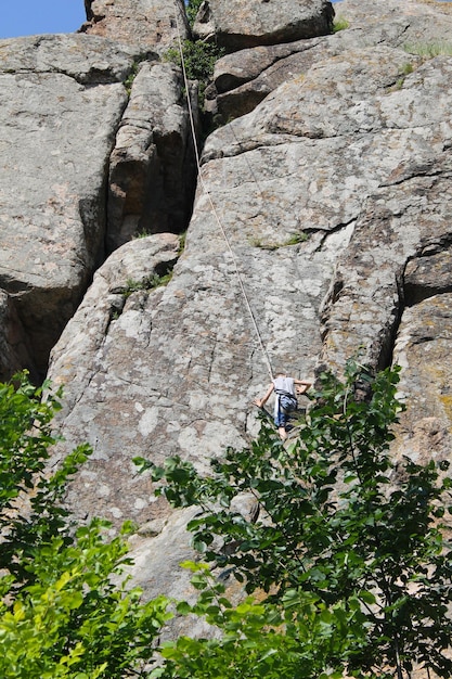 Menino escalando na rocha