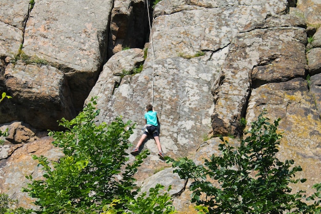 Menino escalando na rocha
