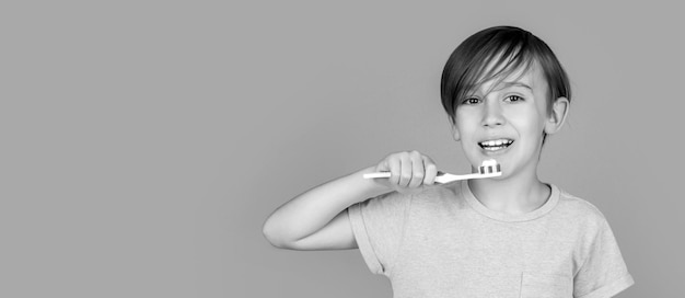 Menino escova de dentes pasta de dentes branca Cuidados de saúde higiene dental Higiene dental Criança feliz escovando os dentes Garoto escovando os dentes Preto e branco