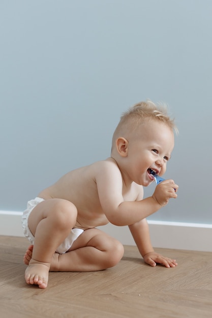 Foto menino escova os dentes com uma escova de dentes e ri