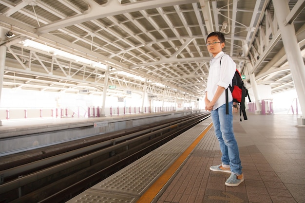 Menino esperando o trem do céu em bangkok, tailândia