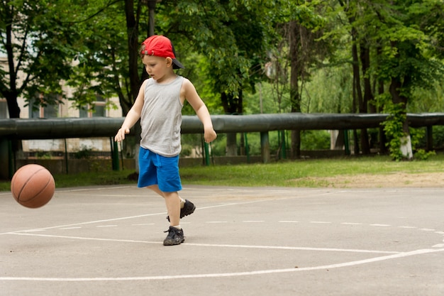 Menino esportivo jogando basquete