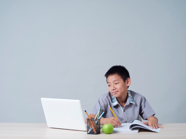 Menino estudando online com o laptop. Aprendizagem à distância durante a pandemia COVID-19