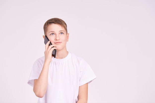 Menino falando ao telefone Camisa branca em fundo cinza Masculino