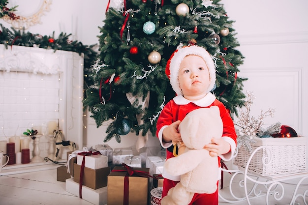 Menino fantasiado de Papai Noel com interior claro