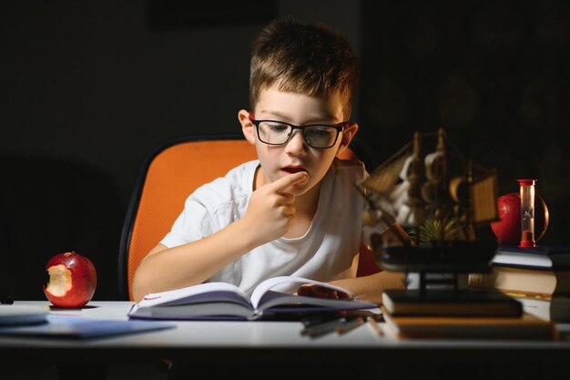 Menino fazendo lição de casa em casa à noite