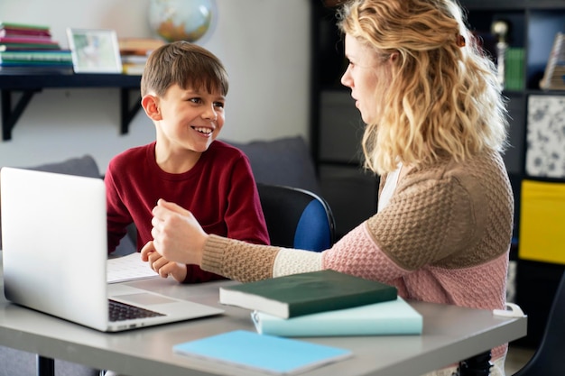 Menino feliz com sua mãe enquanto faz trabalhos de casa