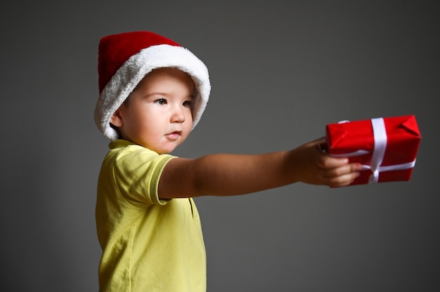 Menino feliz da criança com caixa de presente de Natal. Feliz ano novo e conceito de férias de Natal. Foto de alta qualidade