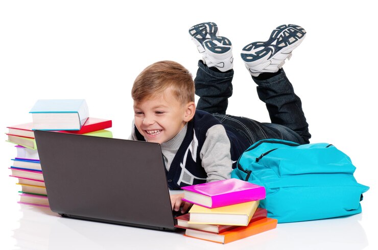 Foto menino feliz deitado no chão com laptop e livros isolados em fundo branco