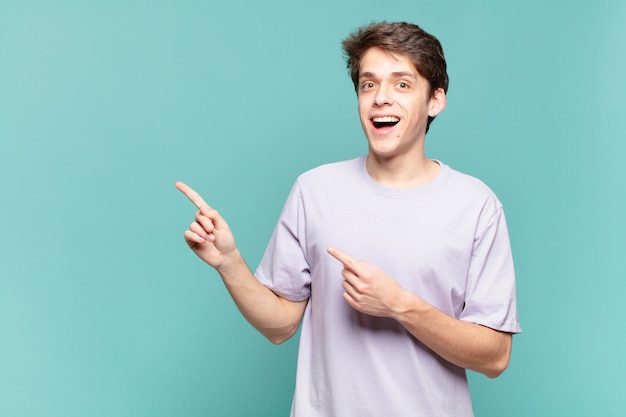 Menino feliz e surpreso, sorrindo com uma expressão chocada e apontando para o lado