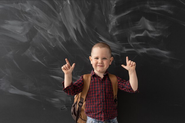 Foto menino feliz na escola fica na lousa.