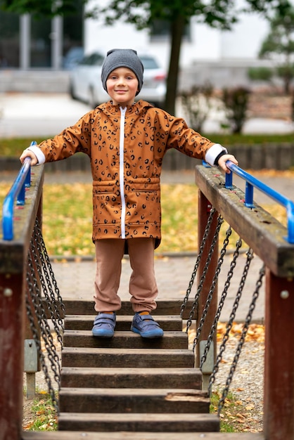 Menino feliz na moda vestido no playground